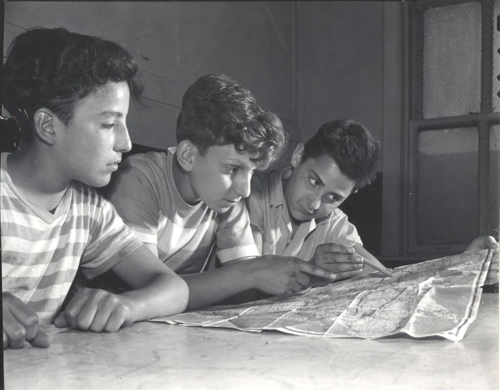 Miniature of Three boys looking at a map