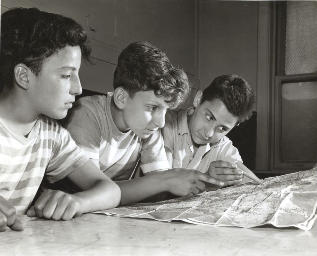 Three boys looking at a map