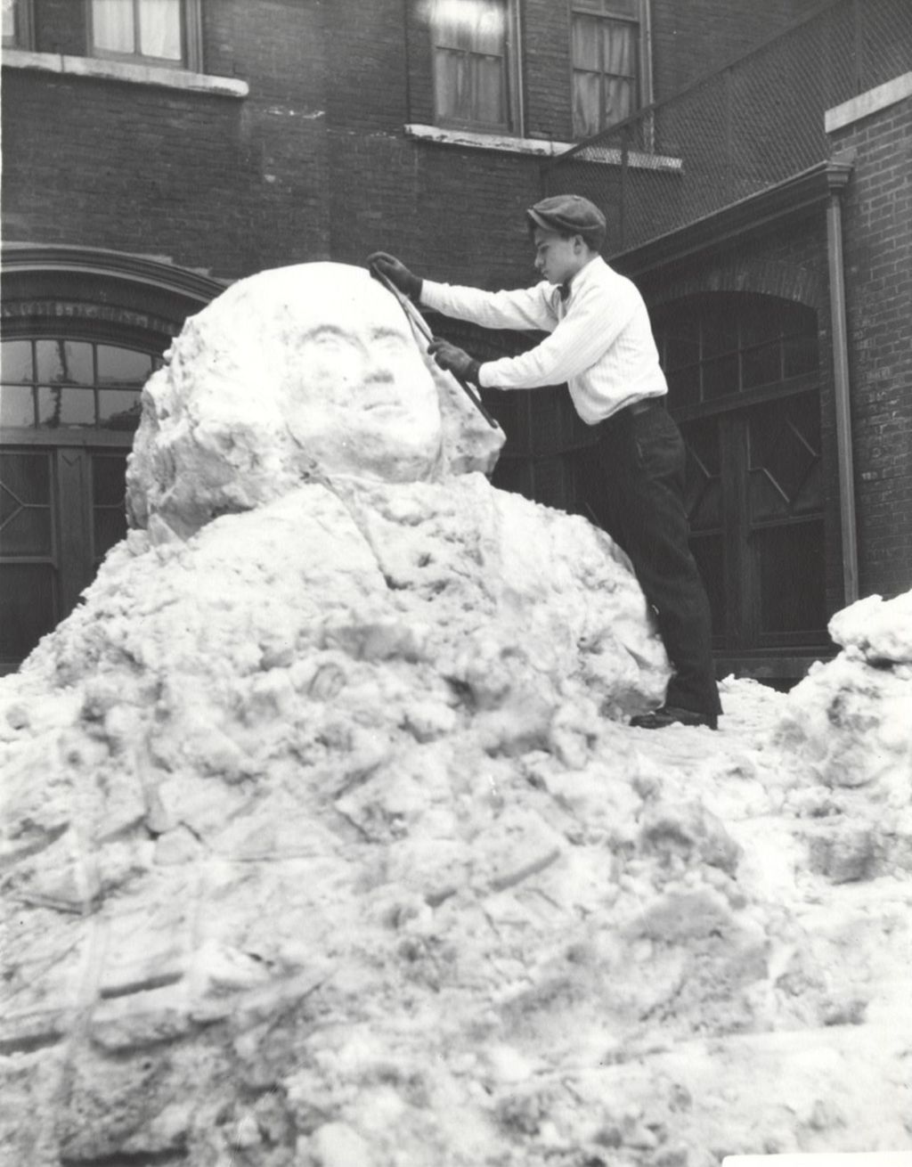 Young man creating snow sculpture