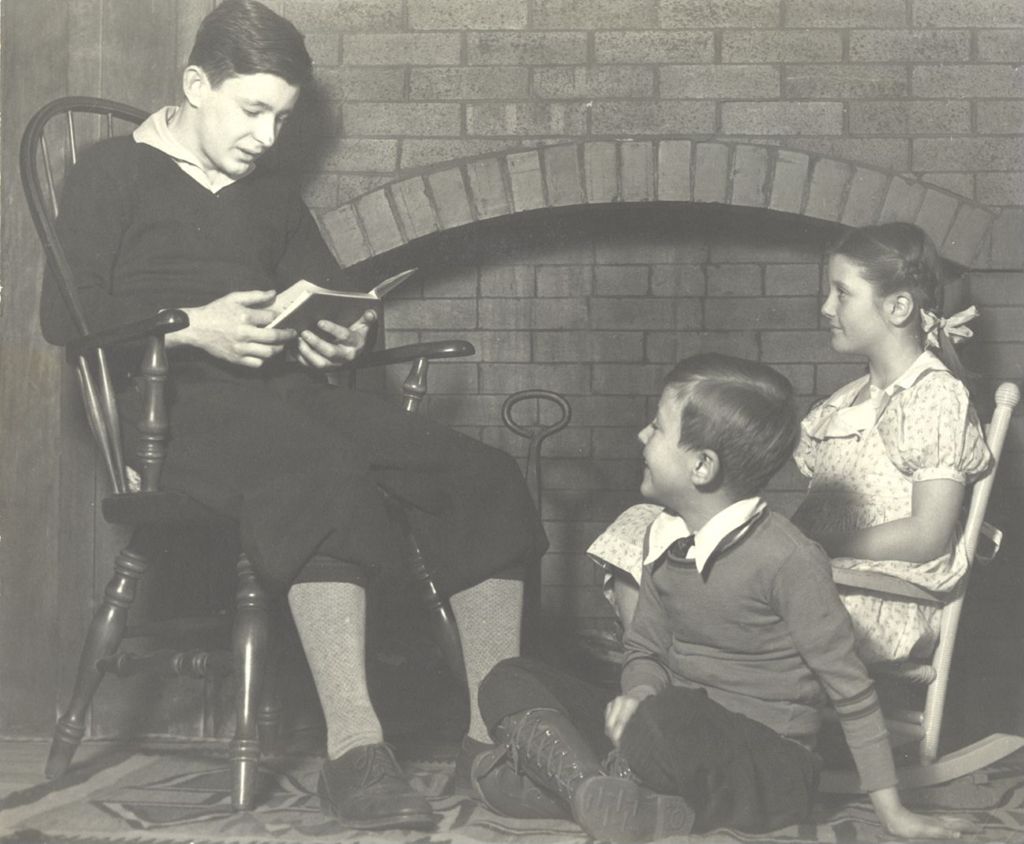 Miniature of Man reading to two children by fireplace