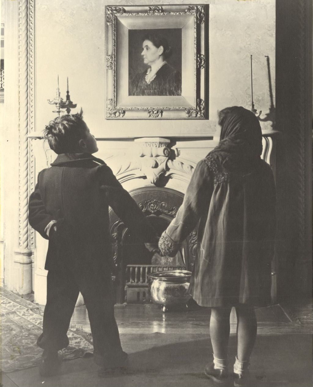 Miniature of Boy and girl holding hands while looking up at a portrait of Jane Addams