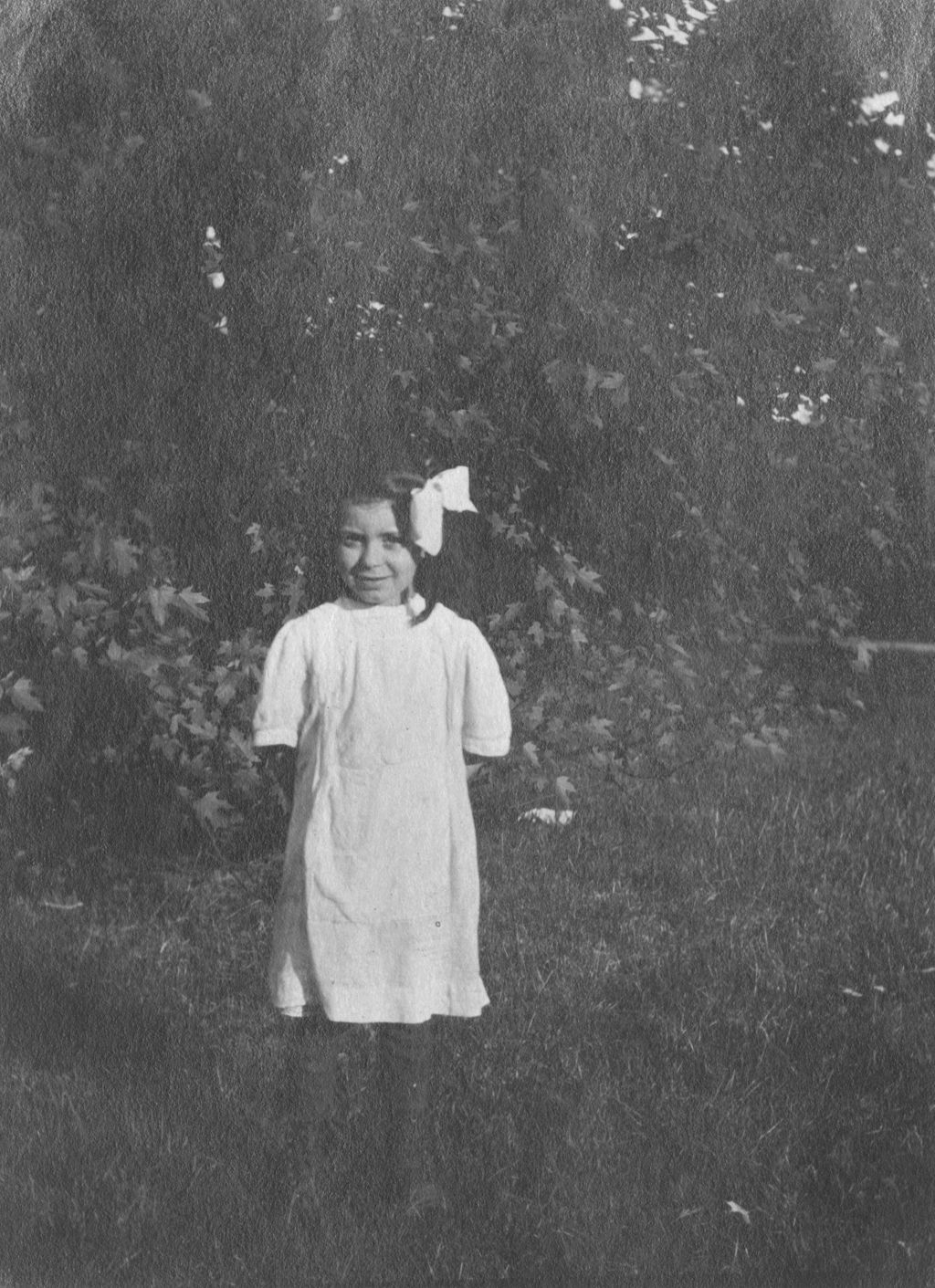 Miniature of Girl with bow in her hair standing on grass