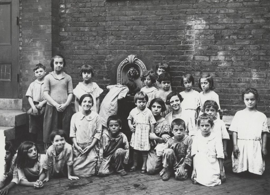 Miniature of Group of children pose for photo in front of wall with drinking fountain