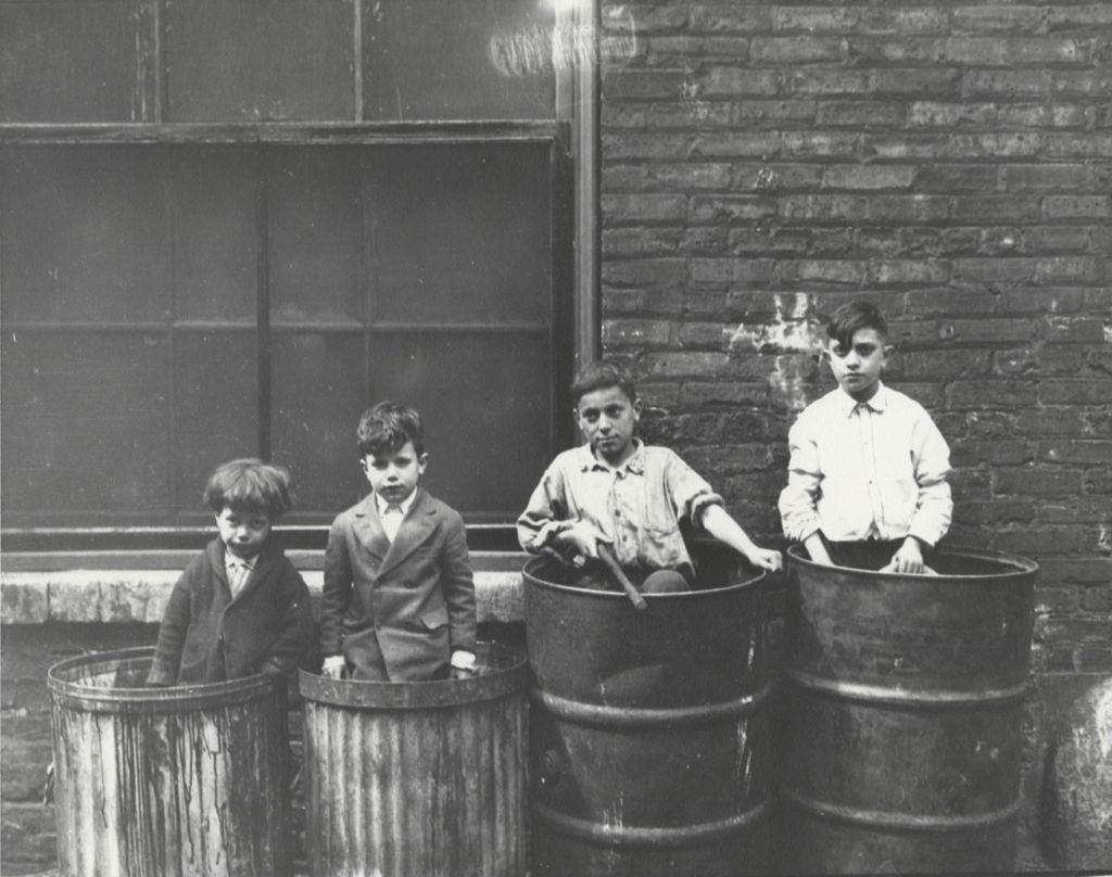Four boys standing in garbage cans in alley near Hull-House