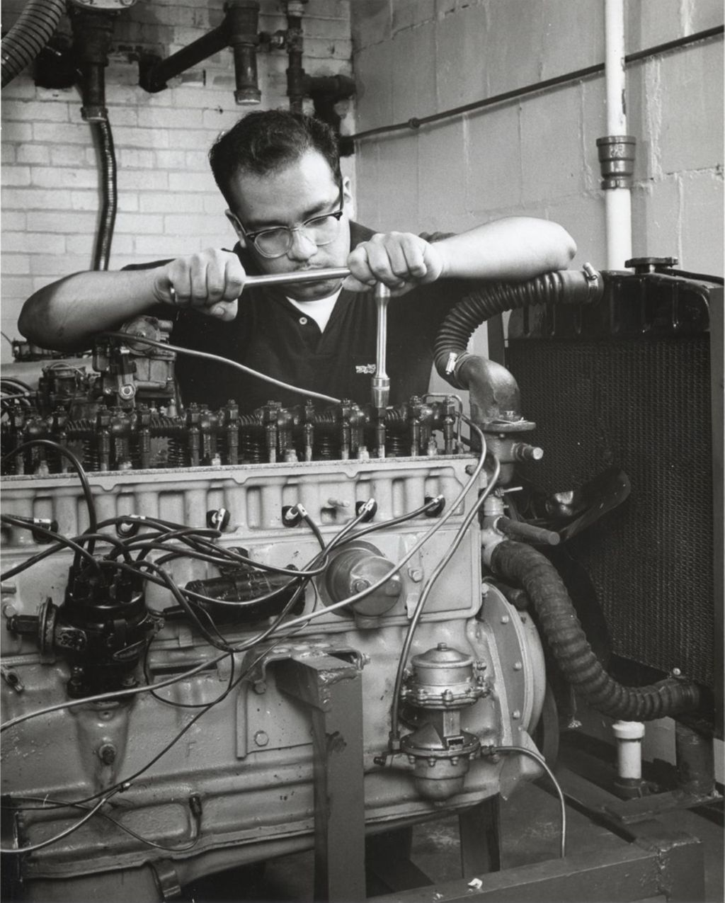 Man working on engine in automobile workshop