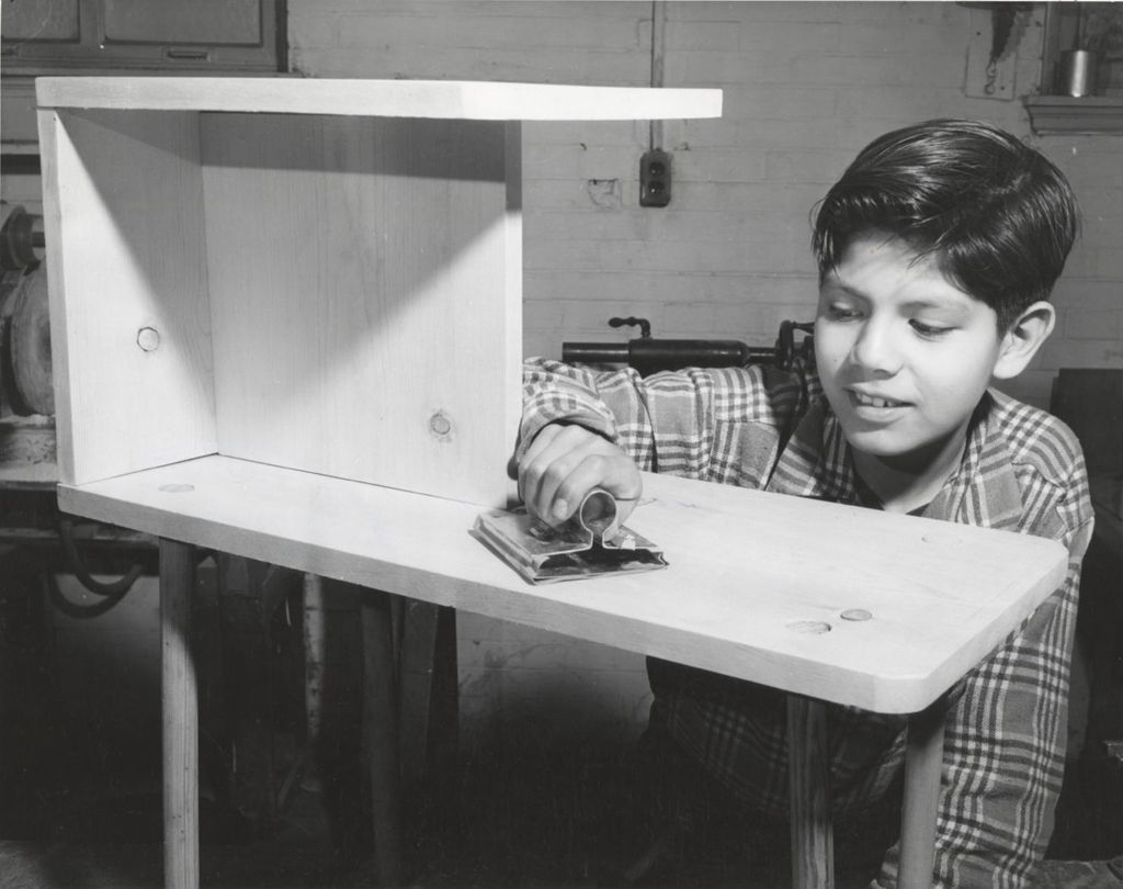 Miniature of Boy sanding furniture in woodworking class