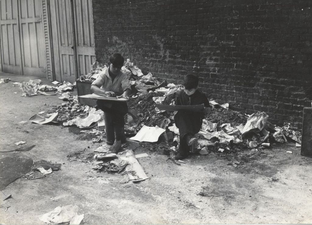 Boys drawing in garbage strewn alley