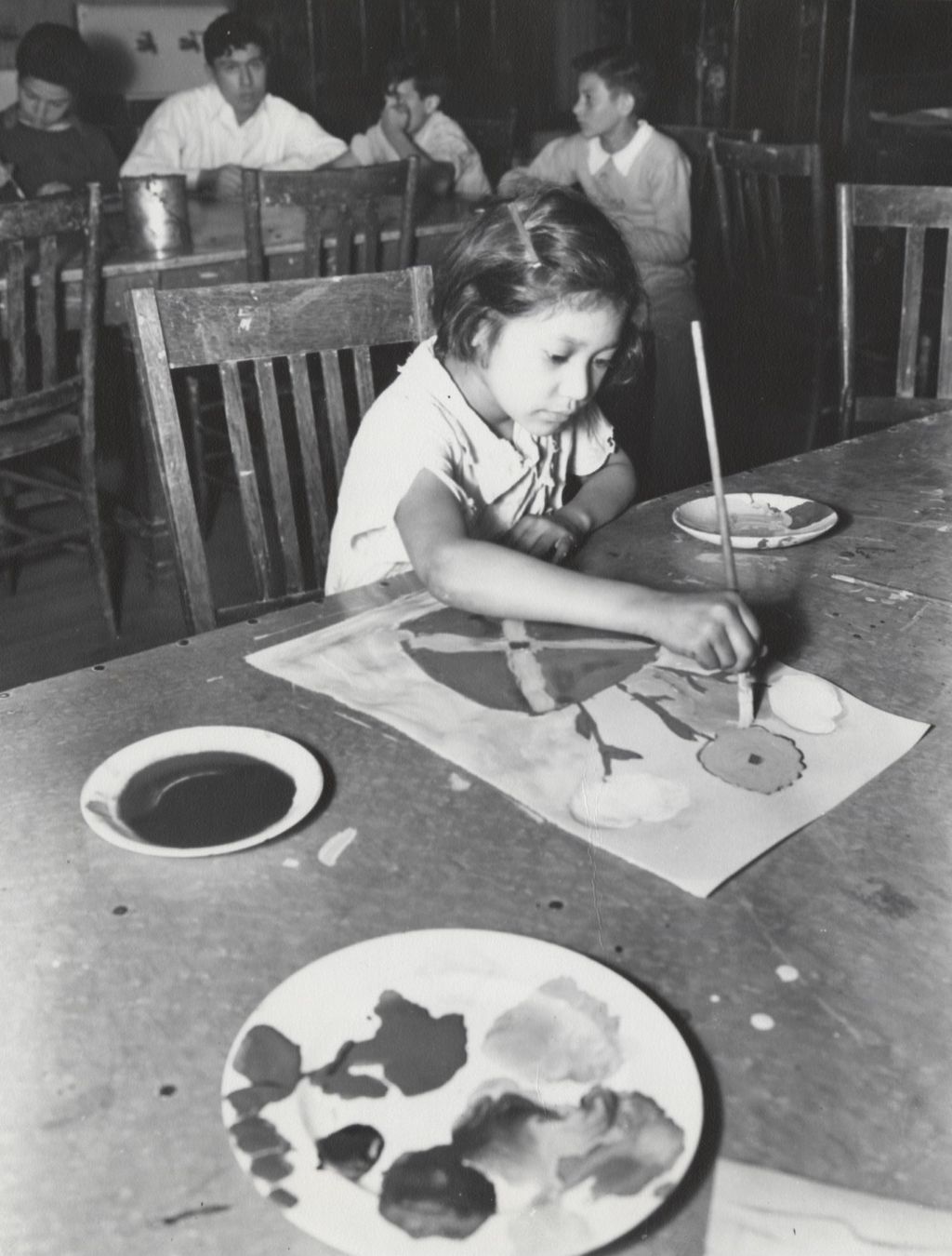 Girl painting picture of flowers in art class