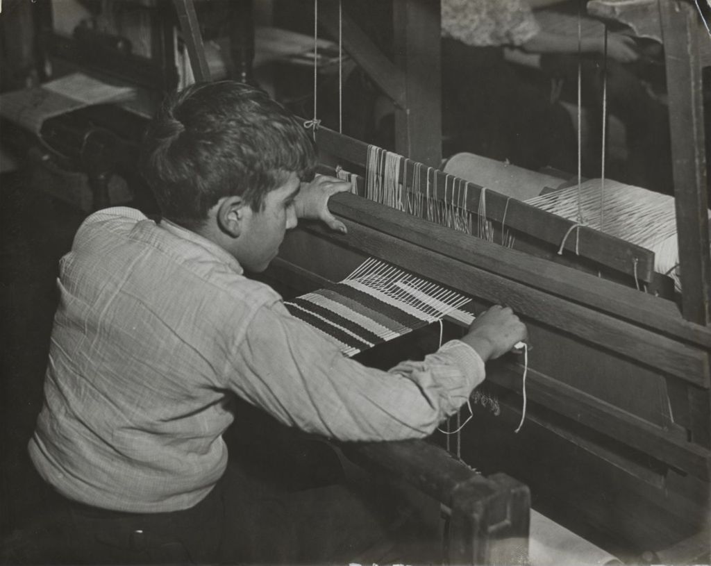 Young man weaving at the loom