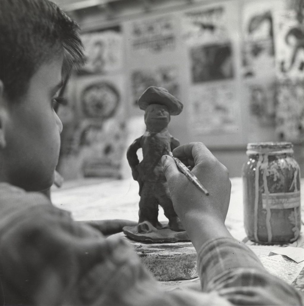 Miniature of Boy working on clay model of man in hat