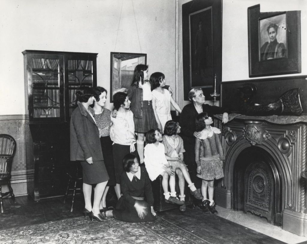 Jane Addams and children looking at portrait of Jenny Dow