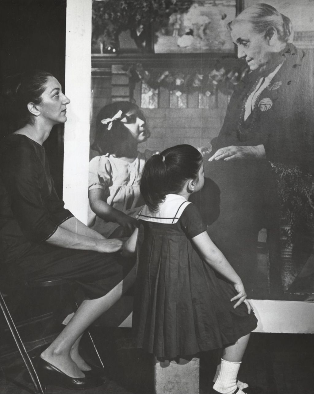Eleanor Pasquale Cannella looking at a photograph of herself as a child with Jane Addams