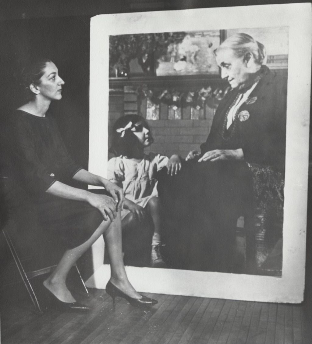 Eleanor Pasquale Cannella looking at a photograph of herself as a child with Jane Addams